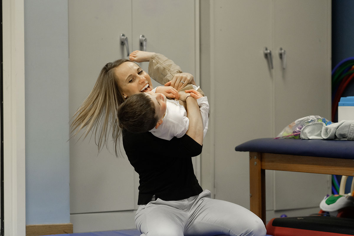 Therapist hugging autistic child